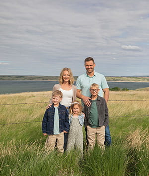 family portrait of Brady and Lindsay funk on an open field with their three children
