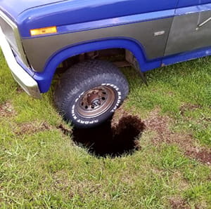 Truck wheel stuck in hole in ground
