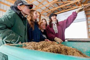 A group of 4-H kids learning in the farm with their mentor