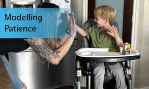 Parent high-fives child sitting in high chair