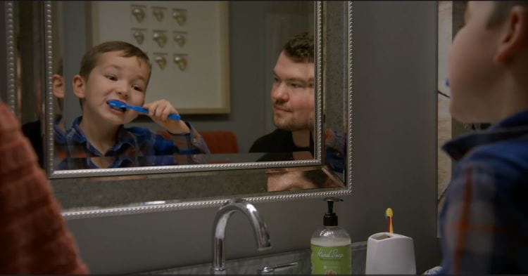 Man watches child brush his teeth