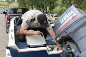 Conservation officer inspecting a boat for invasive species