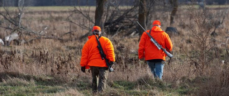 Two hunters with orange apparel on