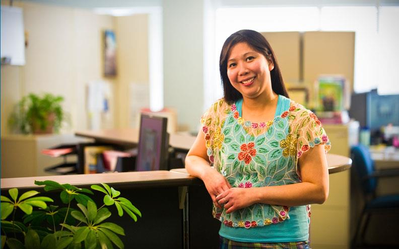 Woman standing next to desk in an office