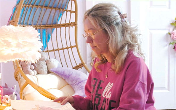 Person reading paperwork while seated in a home setting, representing individuals affected by organ and tissue donation.