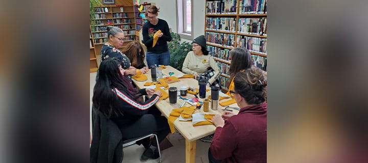 A group of people sitting around a table doing crafts