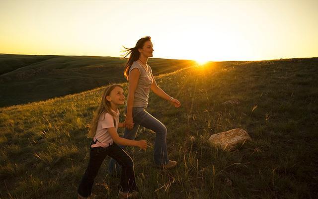 Mother and daughter walking on a hill