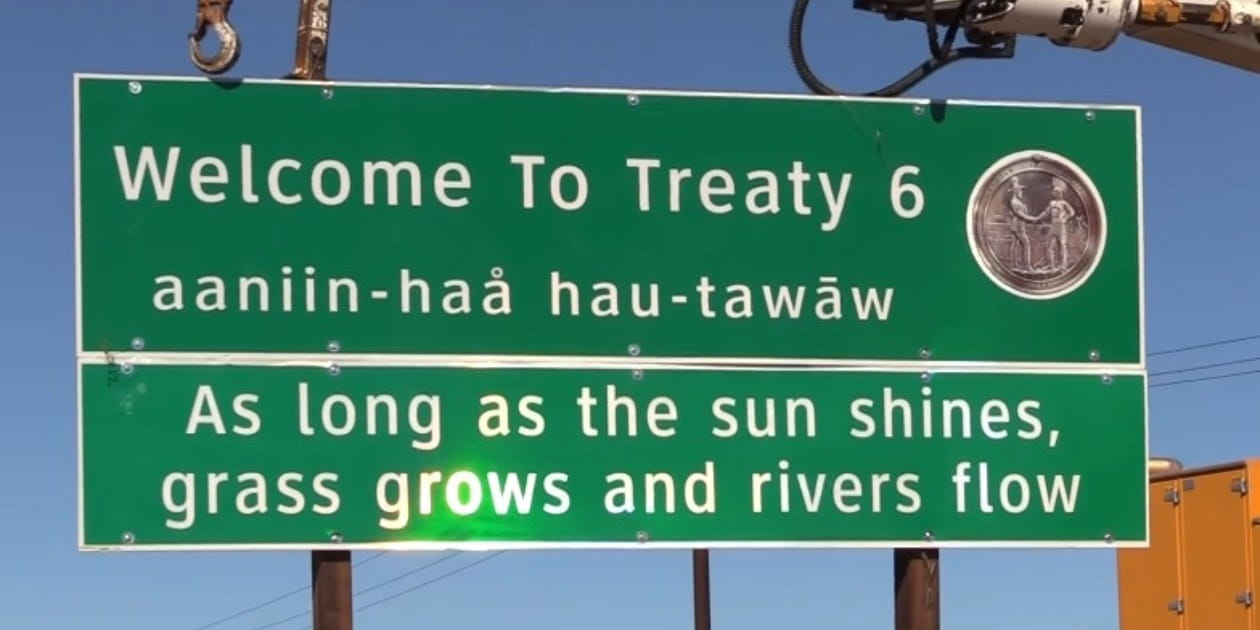 Highway sign that says "Welcome to Treaty 6 - As long as the sun shines, grass grows and rivers flow" in English and Cree