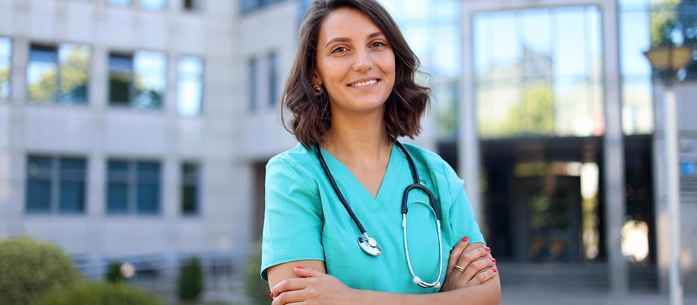 Female health care professional wearing stethoscope, smiling