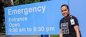 Health-care worker in front of Emergency sign