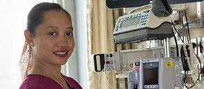 Health care worker in front of medical equipment