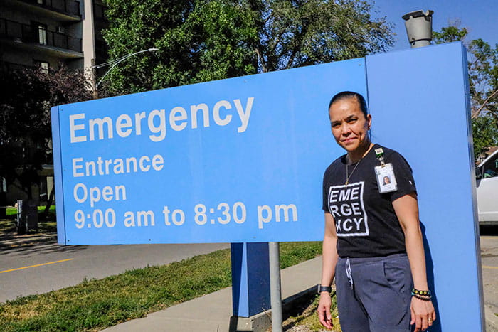 Carmela Estorco at work in front of emergency sign