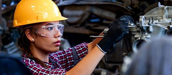 A female worker wearing hardhat and safety glasses