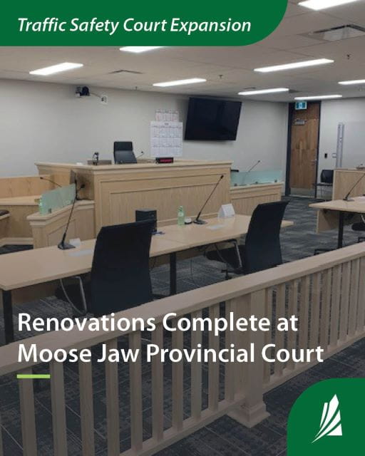 A newly renovated court room with light wood desks and Bench.  Text reads Traffic Safety Court Expansion. Renovations Complete at Moose Jaw Provincial Court.
