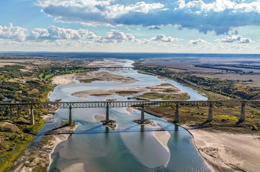 Outlook, SK - Brodie Sollid - 2025 Woods & Water Winner An aerial view, facing towards the old Outlook Railway Bridge in Outlook, Saskatchewan. This image, taken by Brodie Sollid, is one of the winners of the 2025 ExploreSask Photo Contest.