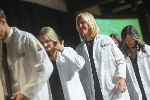 Medical students walking in a white coat ceremony